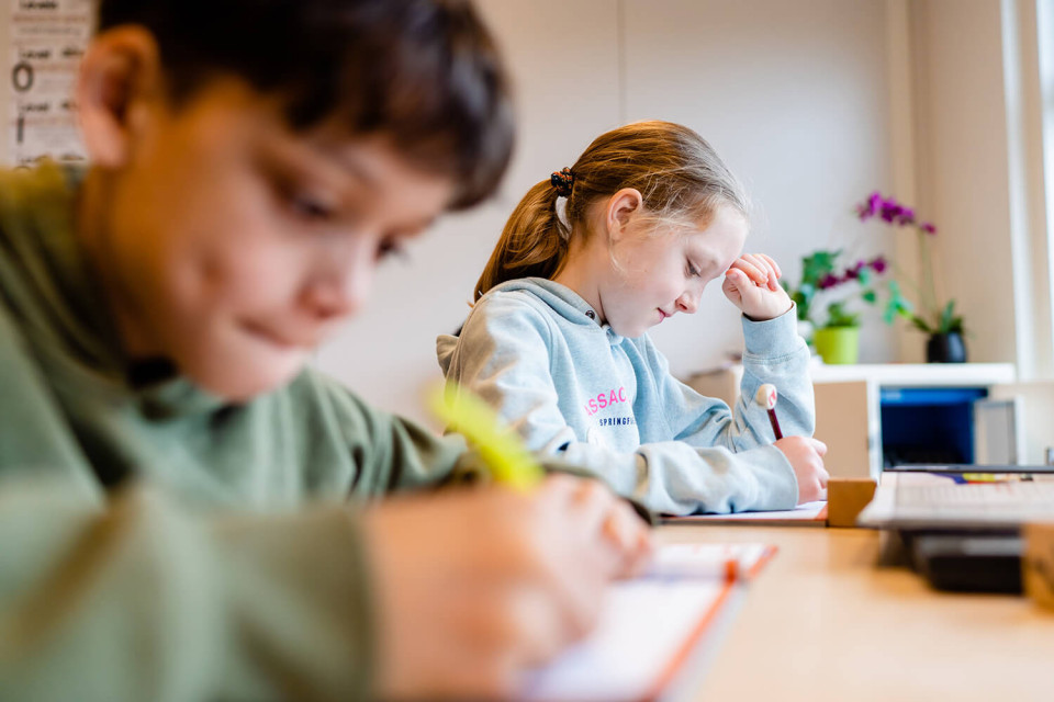 Meisje aan het werk met een potlood in haar hand